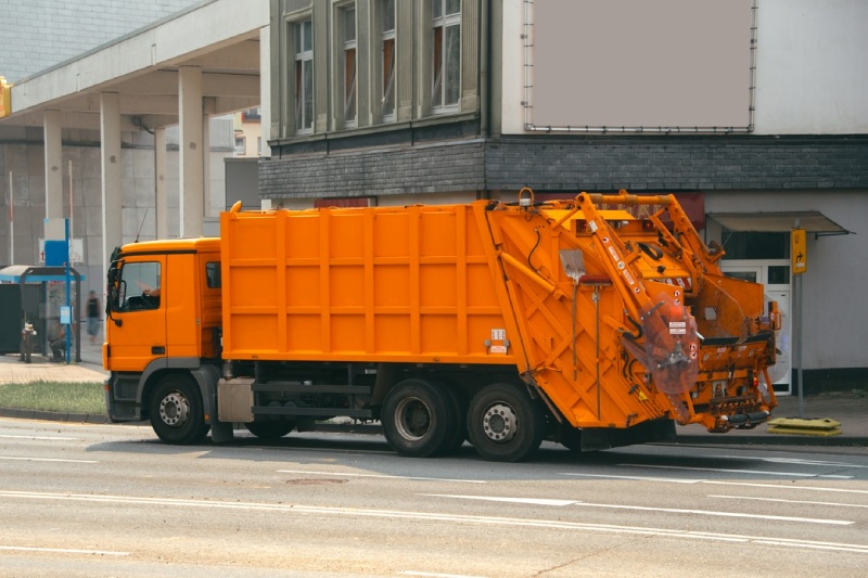 pomarańczowa śmieciarka samochodowa